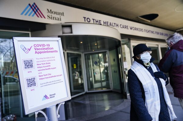 People wearing protective masks during the coronavirus pandemic enter and exit Mount Sinai hospital Wednesday, Feb. 17, 2021, in New York. "Unfortunately, due to sudden changes in vaccine supply, we have been forced to cancel existing public vaccination appointments," said a hospital spokesperson. (AP Photo/Frank Franklin II)
