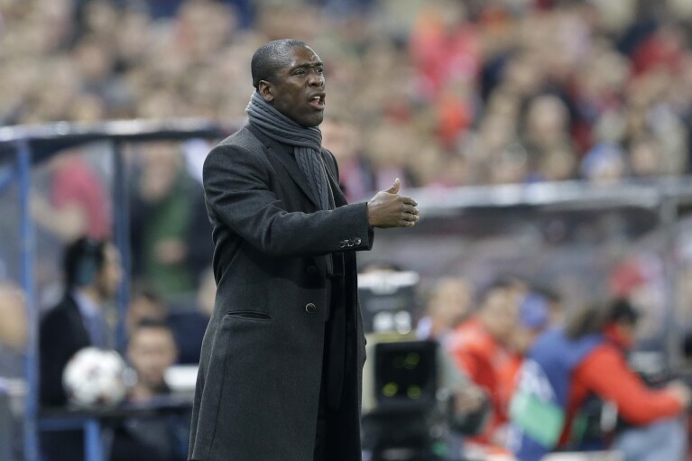 FILE - AC Milan coach Clarence Seedorf signals to his players during a Champions League, round of 16, second leg, soccer match between Atletico Madrid and AC Milan at the Vicente Calderon stadium in Madrid, Tuesday March 11, 2014. Racism has long permeated the world's most popular sport, with soccer players subjected to racist chants and taunts online. While governing bodies like FIFA and UEFA have taken steps to combat the abuse of players, the lack of diversity in the upper ranks at major clubs remains an unsolved problem. Seedorf was hired by Italian giant AC Milan in 2014 but lasted only four months. (AP Photo/Paul White, File)