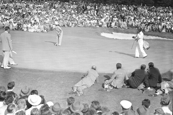 FILE - Sam Snead sinks a 20-foot putt on the 18th green to win the Masters Tournament in Augusta, Ga., April 10, 1949. His win 75 years ago was the first time the champion was presented a green jacket. (AP Photo/Rudolph Faircloth, File)