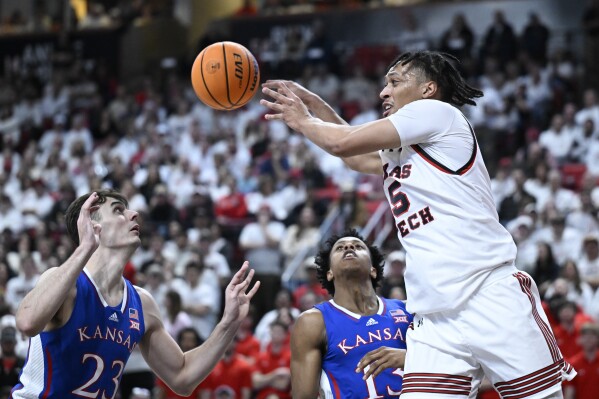 Texas Tech guard Darrion Williams (5) passes the ball against Kansas forward Parker Braun (23) and guard Elmarko Jackson, center, during the first half of an NCAA college basketball game, Monday, Feb. 12, 2024, in Lubbock, Texas. (AP Photo/Justin Rex)