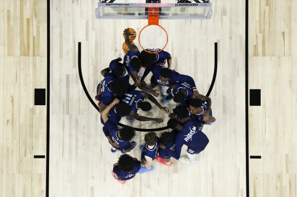 FILE - Saint Peter's players huddle before the second half of a college basketball game against Purdue in the Sweet 16 round of the NCAA tournament, Friday, March 25, 2022, in Philadelphia. The online sports betting company PointsBet committed three different types of violations of New Jersey sports betting laws, including taking bets on soccer games that had already ended, according to gambling regulators who fined the company $25,000. PointsBet accepted bets on March 25, 2022 on the St. Peter's men's basketball team, but which was ineligible to be bet on in New Jersey. The market for St. Peter's bets was live for 55 minutes and two people placed bets, totaling $60. Both were canceled. (AP Photo/Chris Szagola, File)