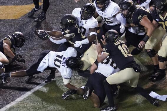 Wake Forest running back Quinton Cooley (28) stretches the ball over the goal line for a touchdown against Army during the first half of an NCAA college football game in Winston-Salem, N.C., Saturday, Oct. 8, 2022. (AP Photo/Chuck Burton)