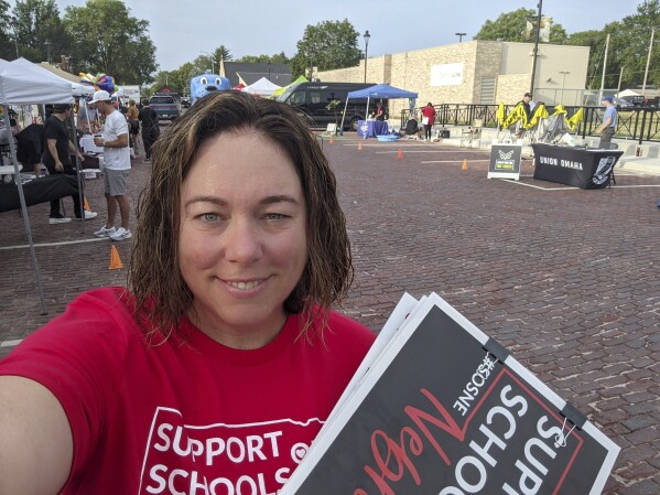In this June 2023 selfie, Angie Lauritsen collects signatures in downtown Gretna, Neb., for a ballot initiative seeking to repeal a state law that would divert taxpayer money to pay for private school tuition. Nebraska lawmakers are set for the first time to pass a bill that would block the public from voting on a ballot measure initiated by citizens of the state, setting up what could be a long battle over whether to fund private school tuition with public dollars. (Angie Lauritsen via AP)