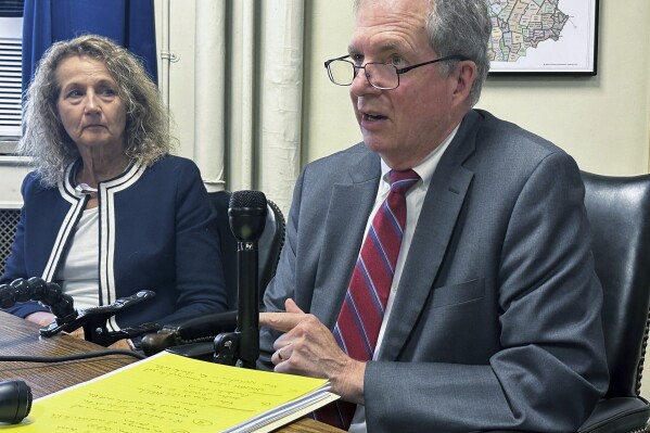 New Hampshire Deputy Secretary of State Patricia Lovejoy, left, looks on as Secretary of State David Scanlan explains that he will not use an amendment to the U.S. Constitution to block former President Donald Trump from the ballot in the state that will hold the first Republican presidential primary next year, at the Statehouse, in Concord, N.H., Wednesday, Sept. 13, 2023. (AP Photo/Holly Ramer)