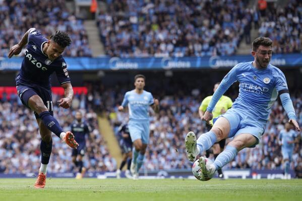 Manchester City's Aymeric Laporte, right, blocks a shot by Aston Villa's Ollie Watkins during the English Premier League soccer match between Manchester City and Aston Villa at the Etihad Stadium in Manchester, England, Sunday, May 22, 2022. (AP Photo/Dave Thompson)