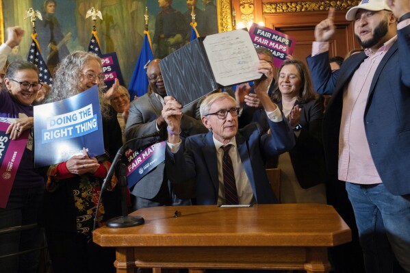 Democratic Gov. Tony Evers shows new signed legislative maps Monday, Feb. 19, 2024, at the Capitol in Madison, Wisconsin. Evers signed new legislative district maps into law that he proposed and that the Republicans who control the Legislature passed to avoid having the liberal-controlled state Supreme Court draw the lines.(Mark Hoffman/Milwaukee Journal-Sentinel via AP)