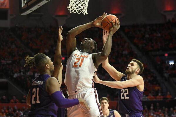 Illinois' Kofi Cockburn (21) lays up the ball against Northwestern's Pete Nance (22) and Elyjah Williams during the first half of an NCAA college basketball game Sunday, Feb. 13, 2022, in Champaign, Ill. (AP Photo/Michael Allio)