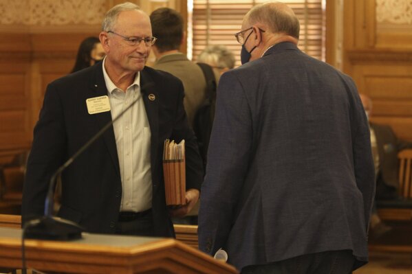In this photo from Friday, March 26, 2021, Kansas state Rep. Randy Garber, left, confers with Rep. John Eplee, R-Atchison, following a House committee's discussion of a bill legalizing the medical use of marijuana, at the Statehouse in Topeka, Kan. The committee has approved the bill, with both Garber and Eplee supporting it. (AP Photo/John Hanna)