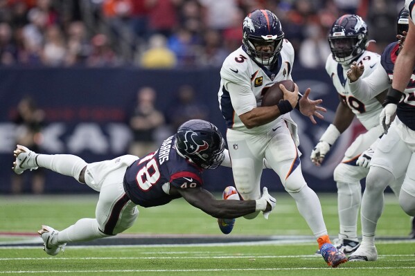 Denver Broncos quarterback Russell Wilson (3) tries to get past Houston Texans linebacker Christian Harris (48) in the first half of an NFL football game Sunday, Dec. 3, 2023, in Houston. (AP Photo/Eric Gay)