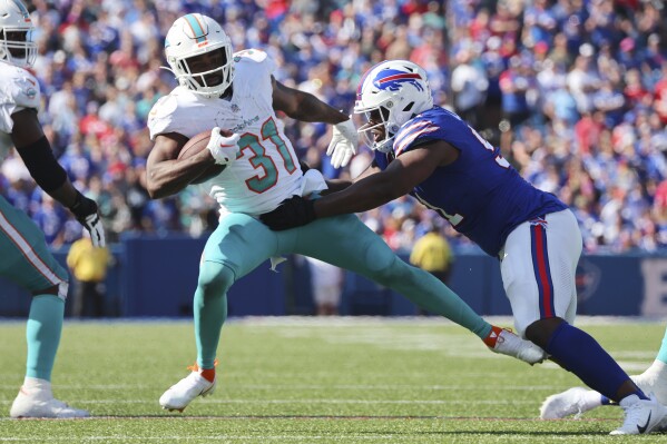 Miami Dolphins running back Raheem Mostert (31) is brought down by Buffalo Bills defensive tackle Ed Oliver, right, during the second half an NFL football game, Sunday, Oct. 1, 2023, in Orchard Park, N.Y. (AP Photo/Jeffrey T. Barnes)