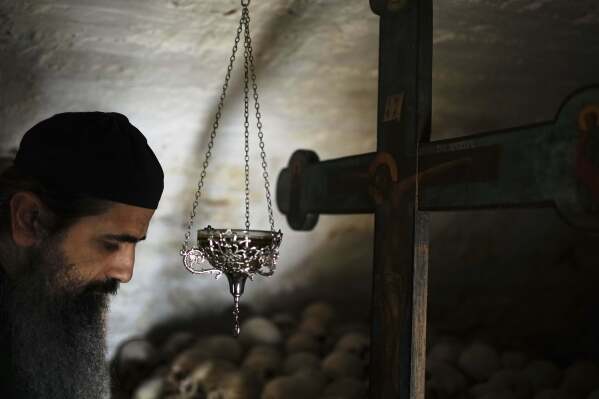 Father Serafeim prays in the ossuary of Simonopetra, or the Simonos Petra Monastery, home of the all-male autonomous community Agion Oros, or Holy Mountain, on the peninsula of Mount Athos in northern Greece, Monday, April 14, 2025. (AP Photo/Thanassis Stavrakis)