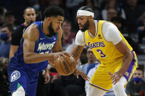 Minnesota Timberwolves center Karl-Anthony Towns (32) works past Los Angeles Lakers forward Anthony Davis (3) in the first quarter of an NBA basketball game Friday, Dec. 17, 2021, in Minneapolis. (AP Photo/Bruce Kluckhohn)