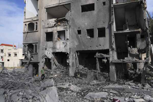 A Palestinian man walks on the rubble of the Al-Zainati family's home, destroyed by Israeli airstrikes in Khan Younis, Gaza Strip, on Thursday, May 15, 2025. (AP Photo/Abdel Kareem Hana)