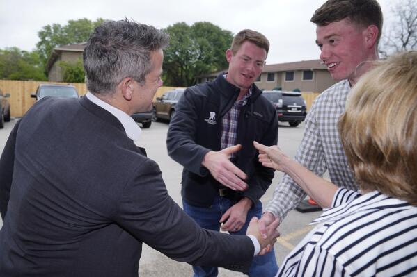 Rep. Adam Kinzinger, R-Ill., left, shakes hands with Grant Goodyear, right, as Texas congressional candidate Michael Wood, center, shakes hands with Linda Thomas Tuesday, April 27, 2021, in Arlington, Texas. Wood is considered the anti-Trump Republican Texas congressional candidate that Kinzinger has endorsed in the May 1st special election for the 6th Congressional District. (AP Photo/LM Otero)