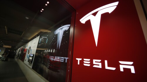 FILE - A sign bearing the Tesla company logo is displayed outside a Tesla store in Cherry Creek Mall in Denver, Feb. 9, 2019. Current and former directors of electric-vehicle maker Tesla Inc. have agreed to return more than $735 million to the company to settle a shareholder lawsuit alleging that they unjustly enriched themselves with excessive compensation. The proposed settlement was outlined in documents filed late Friday, July 14, 2023, in the Delaware Court of Chancery and is subject to court approval. (AP Photo/David Zalubowski, File)