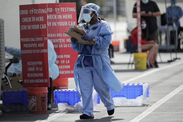 A health care worker works at a COVID-19 testing site sponsored by Community Heath of South Florida at the Martin Luther King, Jr. Clinica Campesina Health Center, during the coronavirus pandemic, Monday, July 6, 2020, in Homestead, Fla. (AP Photo/Lynne Sladky)