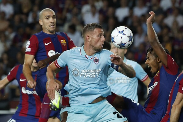 FILE - Royal Antwerp's Toby Alderweireld, centre, fights for the ball during the Champions League Group H soccer match between Barcelona and Royal Antwerp at the Olympic Stadium of Montjuic in Barcelona, Spain, Tuesday, Sept. 19, 2023. Toby Alderweireld is the new face of a campaign against online hate speech promoted by Belgian soccer authorities. The former Belgium international was targeted by messages including threats against his family following a Belgian league match last year. (AP Photo/Joan Monfort, File)