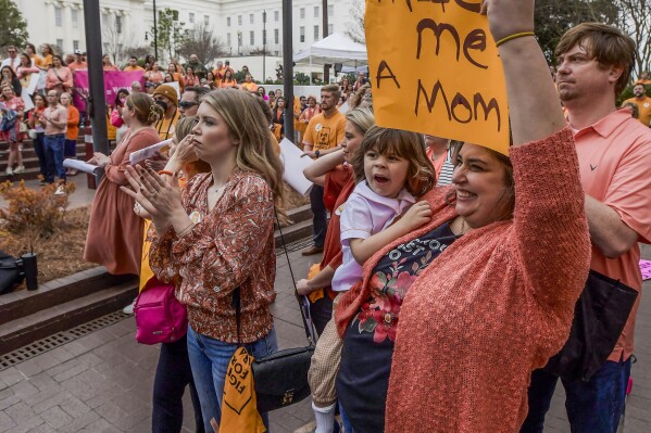 Veronica Wehby-Upchurch a sign and son Ladner Upchurch as hundreds gather for a protest rally for in vitro fertilization legislation Wednesday, Feb. 28, 2024, in Montgomery, Ala. The Alabama Supreme Court ruled, Friday, Feb. 16, 2024, that frozen embryos can be considered children under state law, a ruling critics said could have sweeping implications for fertility treatments. (Mickey Welsh/The Montgomery Advertiser via AP)