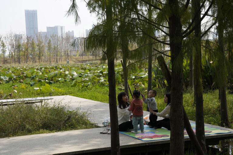 Residents enjoy their day at the "Fish Tail" sponge park that's built on a former coal ash dump site in Nanchang in north-central China's Jiangxi province on Sunday, Oct. 30, 2022. The concept of the park involves creating and expanding parks and ponds within urban areas to prevent flooding and absorb water for times of drought. (AP Photo/Ng Han Guan)