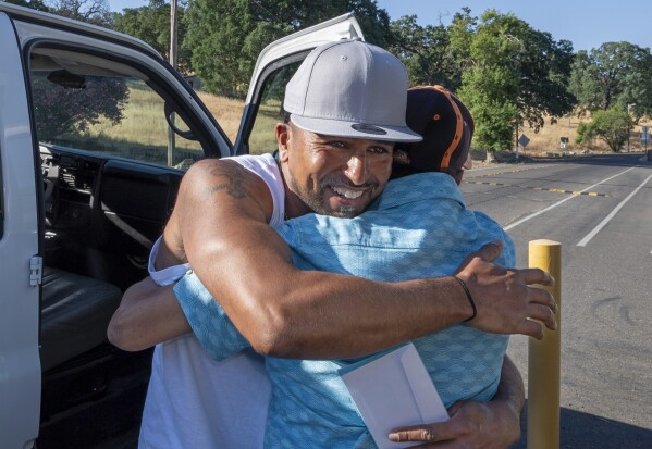 Gerald Massey, left, hugs his father, John Massey, after his release from Folsom State Prison in Folsom, Calif., Monday, July 3, 2023. Gerald Massey was released on parole after serving nine years of a 15-to-life sentence for a drunk driving incident that killed his close friend. (AP Photo/Rich Pedroncelli)