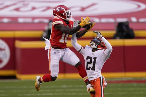 FILE - Kansas City Chiefs wide receiver Tyreek Hill makes a catch over Cleveland Browns cornerback Denzel Ward (21) during the second half of an NFL divisional round football game, Sunday, Jan. 17, 2021, in Kansas City. The Chiefs could have paid Tyreek Hill handsomely and gone all-in on another championship run. Instead, they dealt him to the Dolphins for a package of draft picks and some financial flexibility. In doing so, they took a championship window that might have lasted a few years and extended it by several more. It was a difficult decision, though, and one the Bengals – their opponent in Sunday’s AFC title game – will soon face. (AP Photo/Charlie Riedel, File)