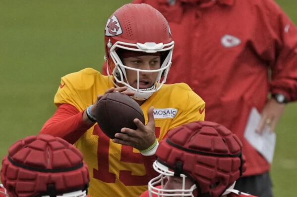 Kansas City Chiefs quarterback Patrick Mahomes throws while head coach Andy Reid watches during NFL football training camp Friday, Aug. 4, 2023, in St. Joseph, Mo. (AP Photo/Charlie Riedel)