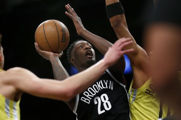 Brooklyn Nets forward Dorian Finney-Smith (28) puts up a shot while being defended by Utah Jazz players during the first half of an NBA basketball game Sunday, April 2, 2023, in New York. (AP Photo/John Munson)