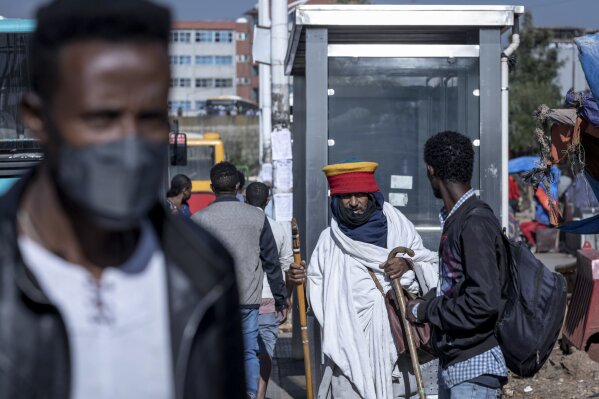 Passengers walk through a bus station in the capital Addis Ababa, Ethiopia Friday, Nov. 6, 2020. Ethiopia's prime minister says airstrikes have been carried out against the forces of the country's Tigray region, asserting that the strikes in multiple locations "completely destroyed rockets and other heavy weapons." (AP Photo/Mulugeta Ayene)