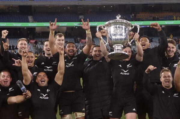 New Zealand's players pose with the Bledisloe Cup after defeating Australia during their rugby union test match in Melbourne, Australia, Saturday, July 29, 2023. (AP Photo/Hamish Blair)