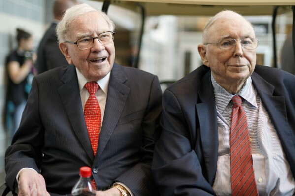 FILE- In this May 3, 2019 file photo, Berkshire Hathaway Chairman and CEO Warren Buffett, left, and Vice Chairman Charlie Munger, briefly chat with reporters before Berkshire Hathaway's annual shareholders meeting. Buffett credited his longtime partner — the late Charlie Munger — with being the architect of the Berkshire Hathaway conglomerate he’s received the credit for leading and warned shareholders in his annual letter not to listen to Wall Street pundits or financial advisors who urge them to trade often. (AP Photo/Nati Harnik, File)