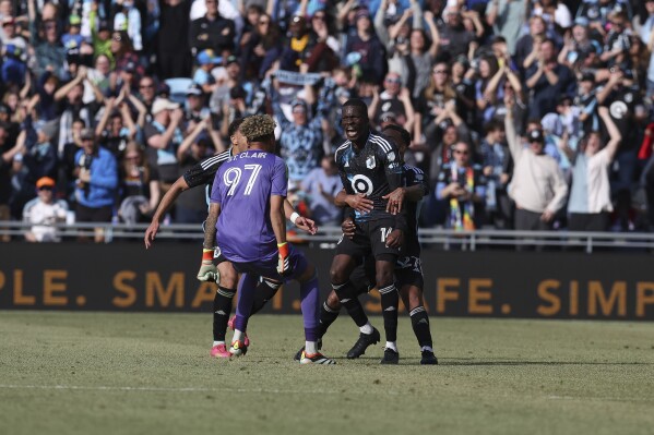 Minnesota United midfielder Tanitoluwa Oluwaseyi (14) celebrates with teammates after making a goal during the second half of an MLS soccer match against the Columbus Crew, Saturday, March 2, 2024, in St. Paul, Minn. (AP Photo/Stacy Bengs)