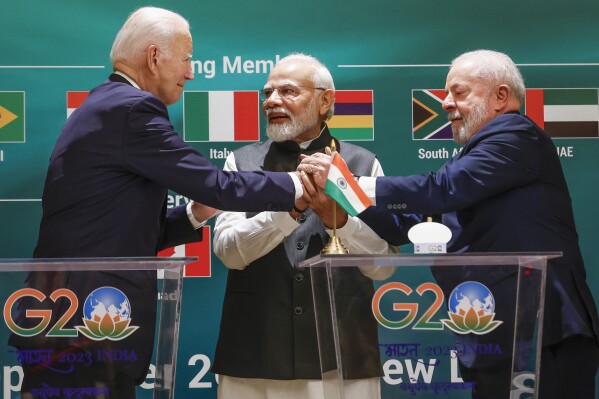 U.S. President Joe Biden, left, Indian Prime Minister Narendra Modi, center, and Brazilian President Luiz Inacio Lula da Silva hold hands as they attend the launch of the Global Biofuels Alliance at the G20 summit in New Delhi, India, Saturday, Sept. 9, 2023. (AP Photo/Evelyn Hockstein, Pool)