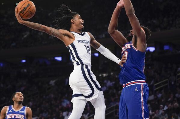 Memphis Grizzlies' Ja Morant, left, is fouled by New York Knicks' Mitchell Robinson, right, as he goes up for a dunk during the second half of an NBA basketball game, Wednesday, Feb. 2, 2022, in New York. The Grizzlies defeated the Knicks 120-108. (AP Photo/Seth Wenig)