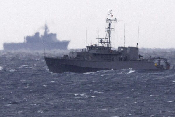 A Japanese Maritime Self Defense Force minesweeper searches in the waters where a U.S. military Osprey aircraft crashed, off Yakushima, Kagoshima prefecture, southern Japan, Friday, Dec. 1, 2023. Japan suspended flights by its Osprey aircraft Thursday, officials said, the day after the U.S. Air Force Osprey based in Japan crashed into the sea during a training mission. (Kyodo News via AP)