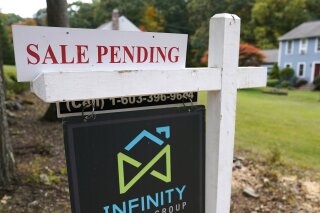 FILE - In this Sept. 29, 2020 file photo, a sale pending sign is displayed outside a residential home for sale in East Derry, N.H. Sales of previously occupied U.S. homes slowed last month as rising prices and a dearth of homes for sale kept some would-be buyers on the sidelines.  (AP Photo/Charles Krupa, File)