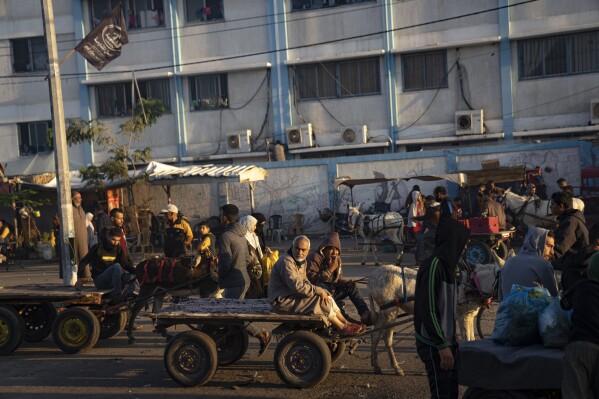 Palestinians ride donkey carts during the ongoing Israeli bombardment of the Gaza Strip in Khan Younis on Friday, Nov. 17, 2023. (AP Photo/Fatima Shbair)