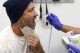 Julio Figuera, 43, has his temperature taken at the Cook County, Ill., medical clinic on Monday, Oct. 16, 2023, in Chicago. "I rarely get sick," he said. "It was the journey that got me sick." Figuera, developed pneumonia since arriving in the U.S. and has been living with hundreds of other asylum seekers at O'Hare International Airport while awaiting more city permanent shelter. When migrants began arriving in Chicago last year, city leaders tapped the county's health system to take over medical care. (AP Photo/Charles Rex Arbogast)