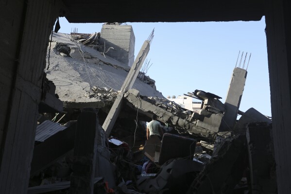 Un palestinese guarda gli edifici distrutti dai bombardamenti israeliani nella Striscia di Gaza, martedì 7 novembre 2023.  (AP Photo/Hatem Ali)
