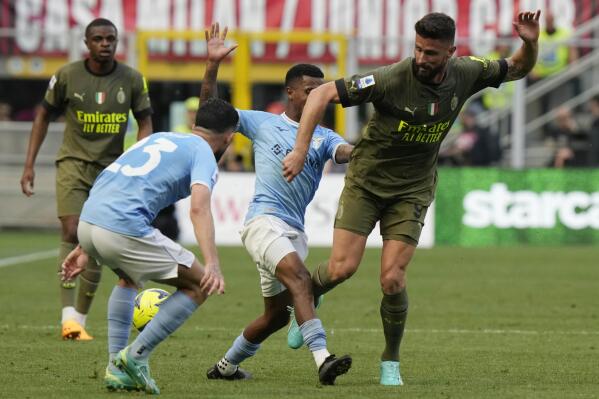 AC Milan's Olivier Giroud, right, challenges for the ball with Lazio's Marcos Antonio during a Serie A soccer match between AC Milan and Lazio, at the San Siro stadium in Milan, Italy, Saturday, May 6, 2023. (AP Photo/Luca Bruno)