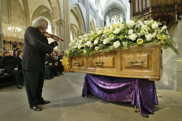FILE - April 3 2004, file, Israeli violinist Ivry Gitlis, ambassador to the UNESCO, plays in front of the coffin of late actor and writer Sir Peter Ustinov during the funeral service at St Pierre's Cathedral in Geneva, Switzerland. Sir Peter died on Sunday aged 82. Ivry Gitlis, an acclaimed violinist who played with famed conductors, rock stars and jazz bands around the world and worked to make classical music accessible to the masses, has died in Paris at 98. (AP Photo/Anja Niedringhaus, File)