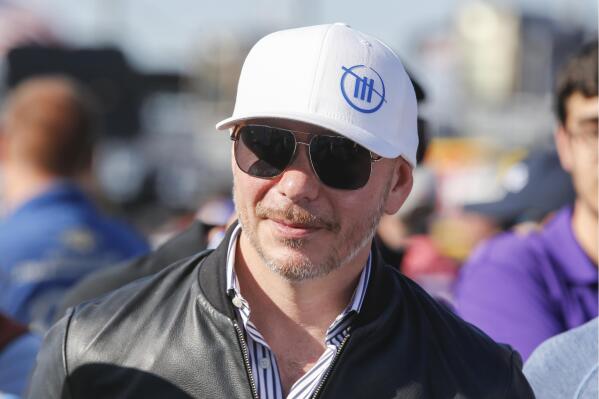Entertainer Pitbull walks through pit road before a NASCAR Cup Series auto race at Charlotte Motor Speedway in Concord, N.C., Sunday, May 30, 2021. Pitbull, known as Mr. Worldwide, is ready to get back to his main business even as he spends more and more time with his latest investment in NASCAR. Pitbull’s new tour titled “I Don’t Know About You But I Feel Good” starts July 25 as the Grammy-winning rapper moves from the racetrack back to the stage. (AP Photo/Nell Redmond)