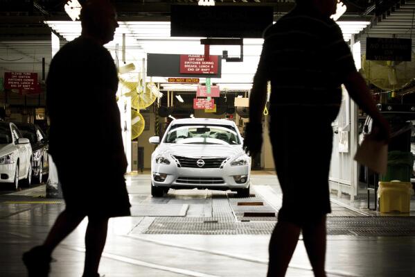 FILE - Workers at the Nissan plant in Smyrna, Tenn., walk by a Nissan Altima sedan, May 15, 2012. A group of 75 employees out of the thousands who work at a Nissan assembly plant in Tennessee will finally vote Thursday, March 16, 2023, on whether to form a union. (AP Photo/Erik Schelzig, File)