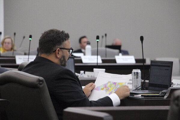 The North Carolina state House reviews copies of a map proposal for new state House districts during a committee hearing at the Legislative Office Building in Raleigh, N.C., Thursday, Oct. 19, 2023. (AP Photo/Hannah Schoenbaum)