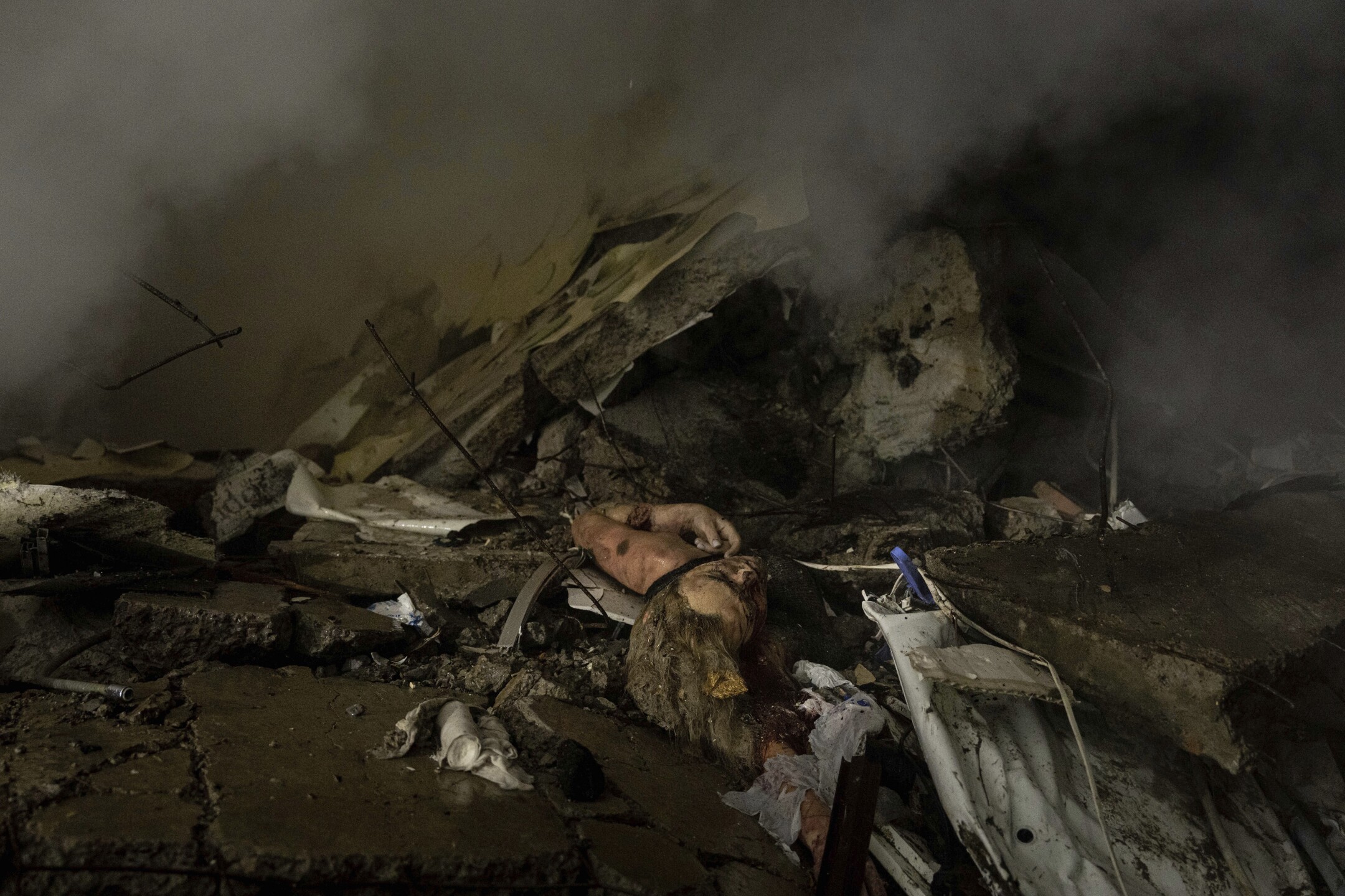 EDS NOTE: GRAPHIC CONTENT - The body of a woman who was killed in a Russian rocket attack on a multistory building lies under rubble in the southeastern city of Dnipro, Ukraine, on Jan. 14, 2023. (AP Photo/Evgeniy Maloletka)