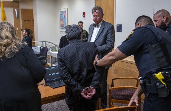 Muhammed Syed, center, with his attorney Thomas Clark, is taken into custody after he was convicted of killing Aftab Hussien in 2022, in Bernalillo County Courthouse in Albuquerque, N.M., Monday, March 18, 2024. (Eddie Moore/The Albuquerque Journal via AP)