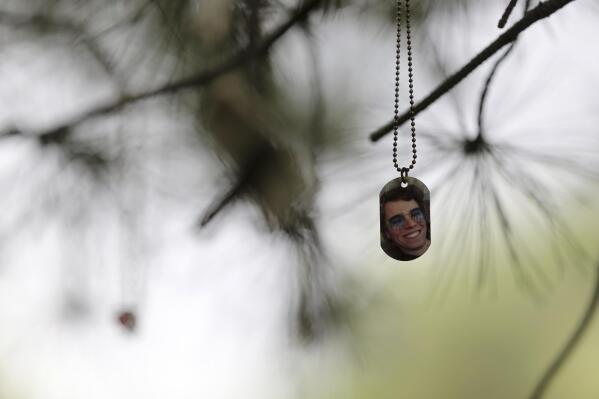 A dog tag with the image of a lost loved one hangs from a tree at the Selah Carefarm in Cornville, Ariz., Oct. 4, 2022. (AP Photo/Dario Lopez-Mills)