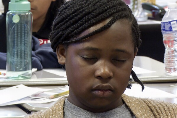 Aniyah Woods meditates during a mindfulness session in her classroom at Roberta T. Smith Elementary School, May 14, 2024, in Rex, Georgia. School districts across the U.S. have been introducing yoga, meditation and mindfulness exercises to help students manage stress and emotions. (AP Photo/Sharon Johnson)