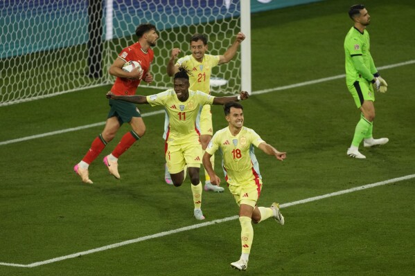 Spain's Martin Zubimendi, front, celebrates after scoring the opening goal against Portugal during the Nations League final soccer match between Portugal and Spain at the Allianz Arena in Munich, Germany, Sunday, June 8, 2025. (AP Photo/Michael Probst)