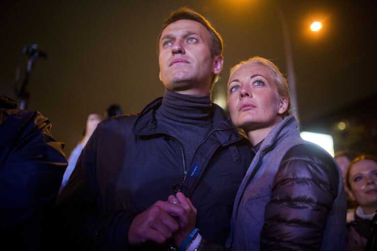FILE - Russian opposition leader Alexei Navalny with his wife Yulia after his last rally in rain-soaked Moscow, Russia, on Sept. 6, 2013. Russia’s prison agency says that imprisoned opposition leader Alexei Navalny has died. He was 47. The Federal Prison Service said in a statement that Navalny felt unwell after a walk on Friday Feb. 16, 2024 and lost consciousness. (AP Photo/Evgeny Feldman, File)