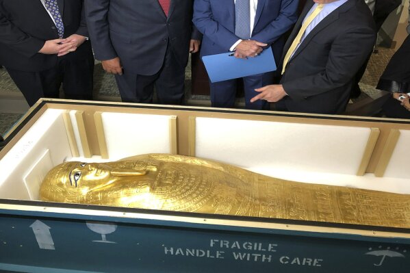 U.S. Homeland Security Investigations special-agent-in-charge Peter Fitzhugh, left, Egyptian Minister of Foreign Affairs Hassan Shoukry center left, Manhattan District Attorney Cyrus Vance Jr., center right and Assistant District Attorney Matthew Bogdanos view the Coffin of Nedjemankh at a repatriation ceremony in New York, Wednesday, Sept. 25, 2019. The coffin, featured at New York's Metropolitan Museum of Art until it was determined to be a looted antiquity, is on its way back to Egypt. (AP Photo/Michael R. Sisak)